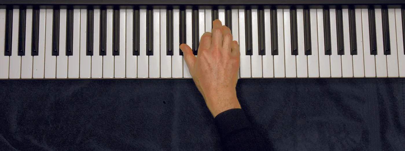 Abaug chord played on a piano — hand position on the keys