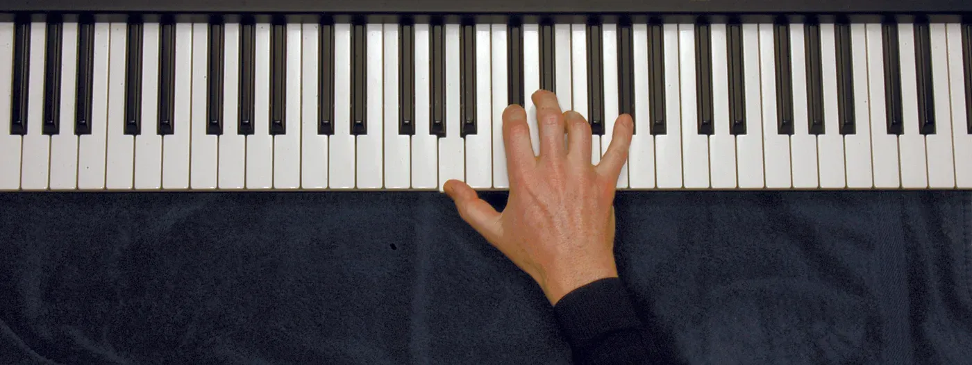 Amaj7 chord played on a piano — hand position on the keys