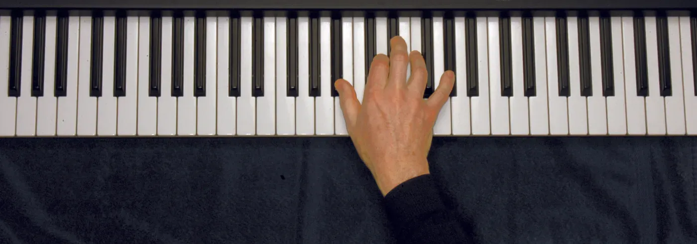 Bb7 chord played on a piano — hand position on the keys