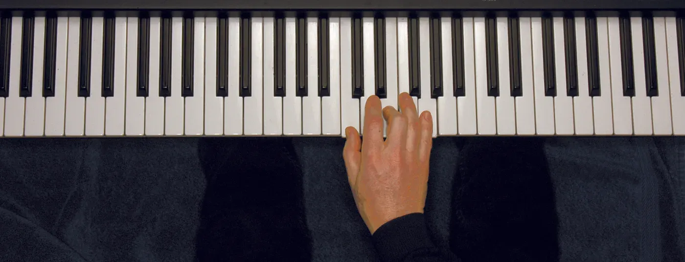 C chord played on a piano — hand position on the keys